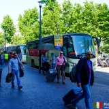Autobus na lotnisko Malpensa, niedaleko jeziora Como. Ludzie z walizkami czekają na transport.