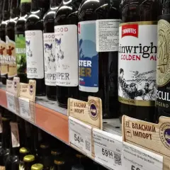 Butelki piwa na półce sklepowej. Zastanawiasz się, ile litrów wina można przywieźć do Polski? Przepisy celne mogą być skomplikowane, ale warto sprawdzić aktualne limity.