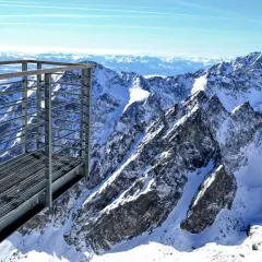 Metalowa kładka widokowa z widokiem na ośnieżone szczyty Tatr Wysokich. Niesamowita panorama Tatrzańskiej Łomnicy.