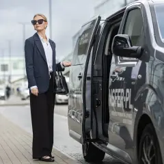 Elegancka kobieta czeka na transfer z Torunia na lotnisko Chopina w Warszawie.
