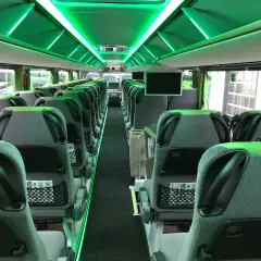 Wnętrze nowoczesnego FlixBus autobus, z zielonym oświetleniem LED i wygodnymi siedzeniami.