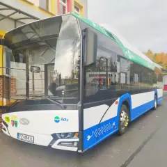 Nowoczesny ebus z numerem 515, ozdobiony zielonymi liśćmi i symbolem wtyczki, gotowy do ekologicznego transportu.