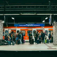 Ludzie z bagażami czekają na pociąg na stacji Regionalbahnhof na lotnisku we Frankfurcie.