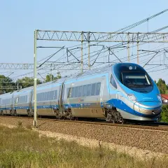 Szybki pociąg Pendolino z charakterystycznym przodem mknie po torach, skrót do szybkiej podróży.