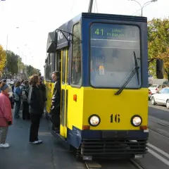 Żółto-niebieski tramwaj linii 41 Łódź Pabianice stoi na przystanku, czekając na pasażerów.