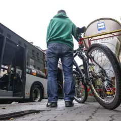 Mężczyzna z rowerem czeka na autobus.