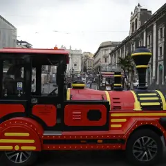 Czerwony pociąg turystyczny "Tourist Dream" na ulicach Katanii, idealny do zwiedzania Syrakuz.