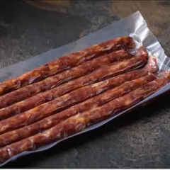 Pakowane próżniowo kiełbaski, idealne na podróż. Czy można przewieźć mięso w samolocie? Takie pakowanie może pomóc.