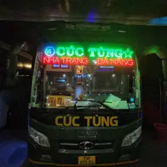 Zielony autobus nocny z neonowym napisem "CÚC TÙNG" i trasą Nha Trang - Da Nang.