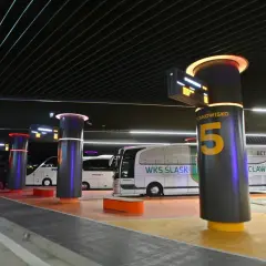 Nowoczesny dworzec PKS Turek z podświetlanymi słupami i tablicami informacyjnymi. Autobusy WKS Śląsk czekają na pasażerów.