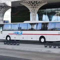 Autobus PKS Biłgoraj czeka na pasażerów przy nowoczesnej wiacie, gotowy do podróży z Krakowa do Katowice Airport.