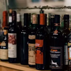 Rząd butelek wina, w tym Chianti Classico, i Aperol. Zastanawiasz się, ile wina można przewieźć z Włoch?