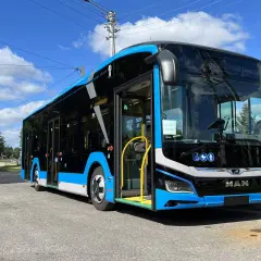 Nowy, niebiesko-czarny autobus MAN, gotowy do kursu Zamość-Kraków, stoi na ulicy.