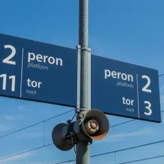 Niebieska tablica informacyjna na dworcu kolejowym wskazuje peron 2, tor 11 oraz peron 2, tor 3.