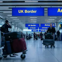 Ludzie z bagażami na lotnisku, kierujący się do UK Border. Zastanawiają się, ile papierosów do Anglii można przewieźć.