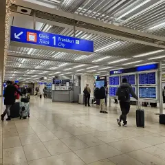Wnętrze dworca kolejowego na lotnisku Frankfurt nad Odrą. Pasażerowie z bagażami czekają na pociąg do Frankfurtu.