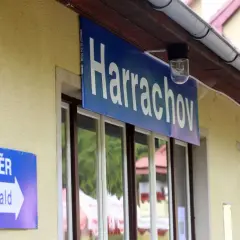 Tabliczka "Harrachov" nad oknami dworca. Obok znak "SMĚR Tanvald" wskazujący kierunek podróży pociągiem ze Szklarskiej Poręby do Harrachova.