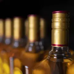 Złote kapsle butelek z alkoholem, przypominające o tym, ile alkoholu można przywieźć z USA do Polski.