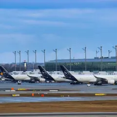 Samoloty Lufthansa na płycie lotniska, w tle nowoczesny terminal. Monachium dworzec autobusowy to nie to miejsce, ale podróż samolotem zaczyna się tutaj.