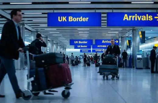 Ludzie z bagażami na lotnisku, kierujący się do UK Border. Zastanawiają się, ile papierosów do Anglii można przewieźć.
