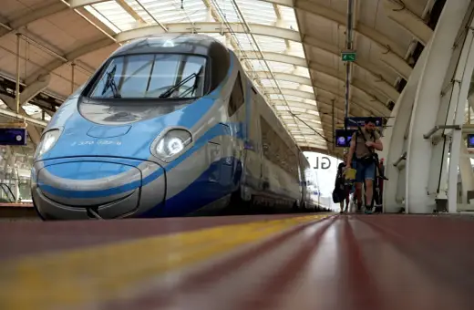 Błękitno-szary Pendolino czeka na pasażerów. Ludzie idą wzdłuż peronu, gotowi do podróży po nowych trasach.