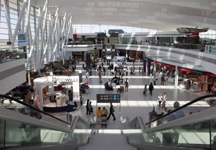 Tętniący życiem terminal lotniska w Budapeszcie. Ludzie poruszają się po nowoczesnej przestrzeni, szukając transportu z lotniska, sklepów i kawiarni.
