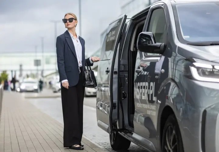 Elegancka kobieta czeka na transfer z Torunia na lotnisko Chopina w Warszawie.