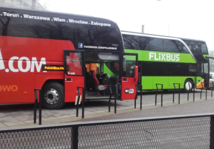 Dwa autokary Flixbus stoją obok siebie. Czerwony autokar ma otwarte drzwi, a zielony autokar z napisem FLIXBUS oferuje zniżki dla emerytów.