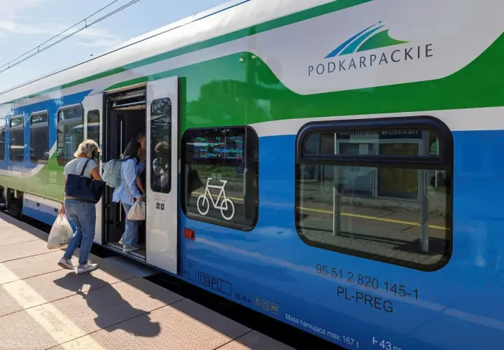 Pasażerowie wsiadają do pociągu Podkarpackiej Kolei Aglomeracyjnej. Na drzwiach widnieje symbol roweru.