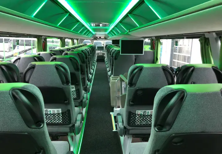 Wnętrze nowoczesnego FlixBus autobus, z zielonym oświetleniem LED i wygodnymi siedzeniami.