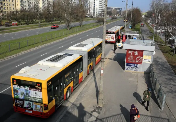 Autobus linii 702 Poznań na przystanku. Zbliża się do zatoczki, gdzie czekają pasażerowie.