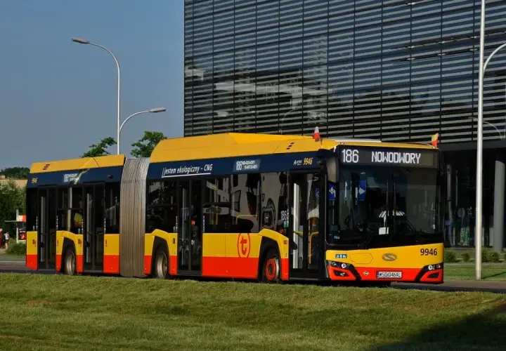 Złoty przegubowy autobus linii 186 jedzie przez Warszawę. Jestem ekologiczny - CNG.