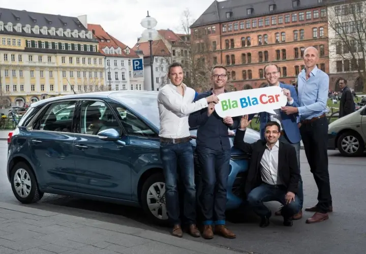 Zespół prezentuje, jak działa BlaBlaCar, stojąc obok samochodu.