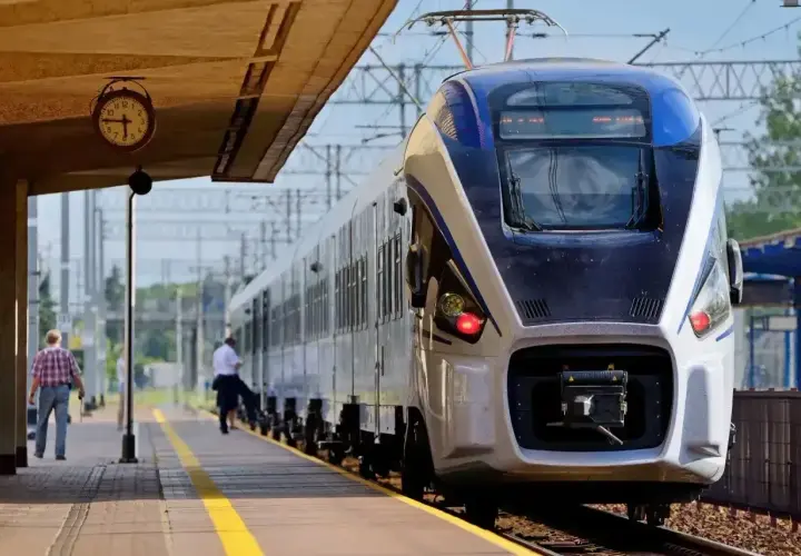 Na dworcu stoi nowoczesny pociąg Intercity. Czy można jechać wcześniejszym pociągiem Intercity? Zegar na peronie pokazuje czas.
