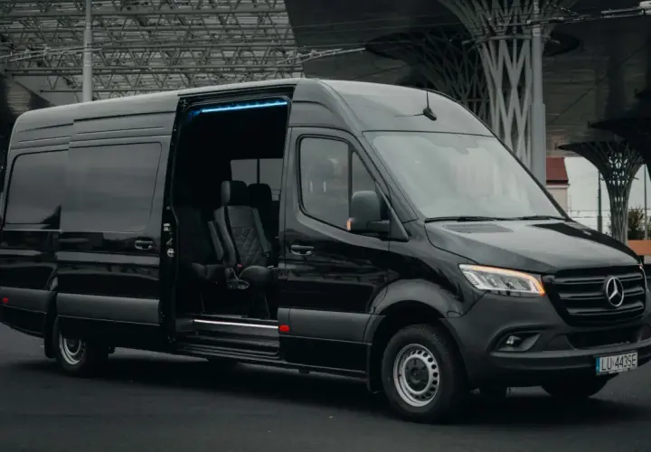 Czarny bus z Niemiec do Polski, z adresu pod adres. Komfortowe fotele i niebieskie oświetlenie wnętrza.