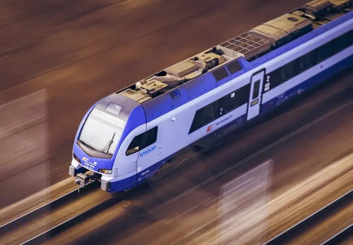 Pociąg Stadler FLIRT PKP Intercity pędzi po torach, jakby był łosiem przemierzającym gdańskie tereny.