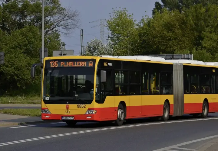 Żółto-czerwony autobus przegubowy linii 135 z napisem "PL.HALLERA" na wyświetlaczu.