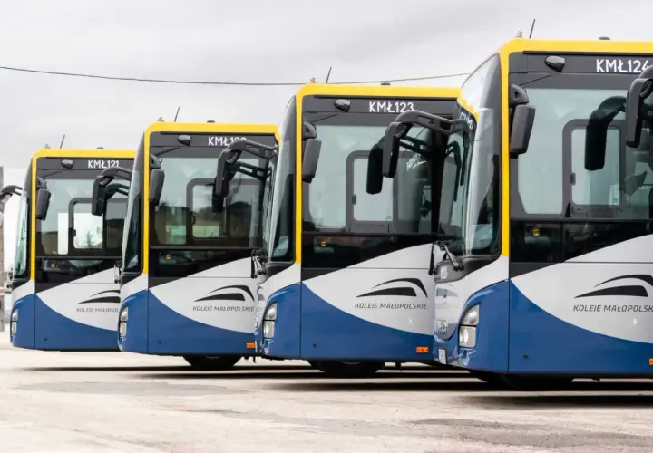 Rząd autobusów Kolei Małopolskich czeka na pasażerów. Busy te obsługują trasę Kraków - Sułkowice, zapewniając sprawne połączenie.