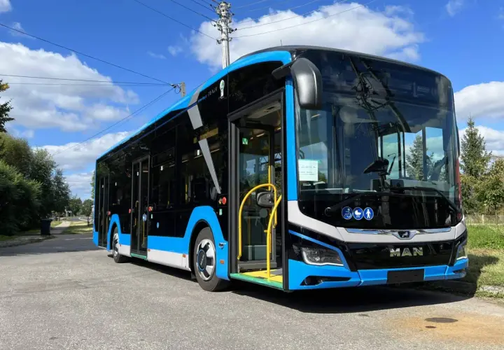 Nowy, niebiesko-czarny autobus MAN, gotowy do kursu Zamość-Kraków, stoi na ulicy.