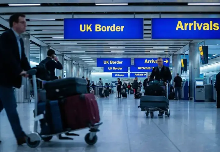 Ludzie z bagażami na lotnisku, kierujący się do UK Border. Zastanawiają się, ile papierosów do Anglii można przewieźć.
