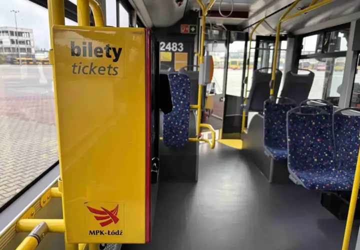 Wnętrze autobusu MPK-Łódź. Żółty automat z napisem "bilety tickets". Sprawdź cenę biletu na trasę Kutno-Łódź.