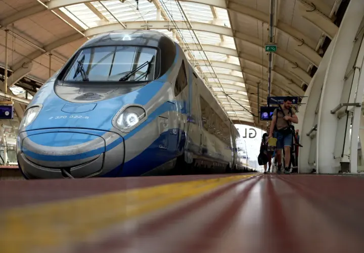 Błękitno-szary Pendolino czeka na pasażerów. Ludzie idą wzdłuż peronu, gotowi do podróży po nowych trasach.