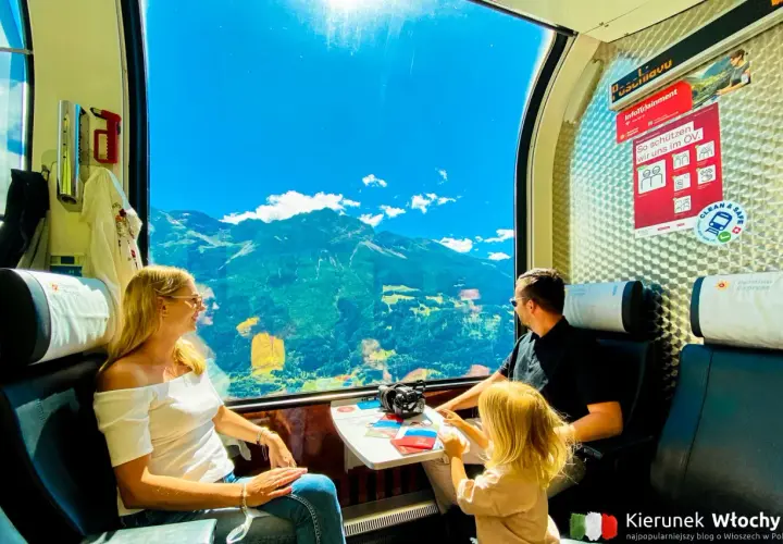 Rodzina podziwia alpejskie widoki przez okno pociągu Bernina Express. Bilety na tę podróż to gwarancja niezapomnianych wrażeń.