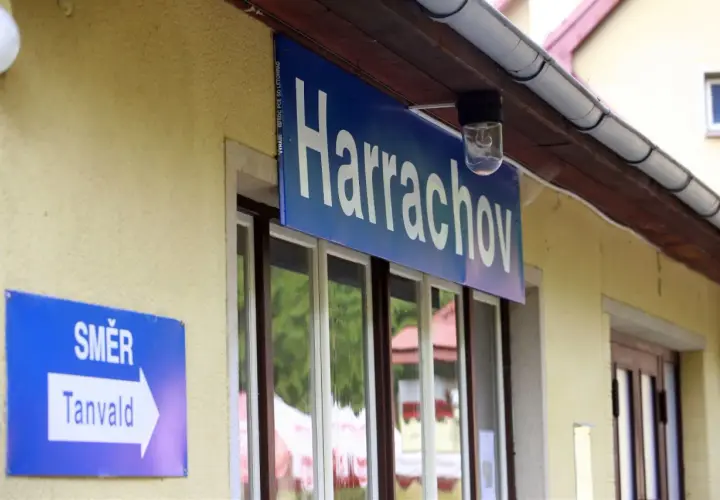 Tabliczka "Harrachov" nad oknami dworca. Obok znak "SMĚR Tanvald" wskazujący kierunek podróży pociągiem ze Szklarskiej Poręby do Harrachova.