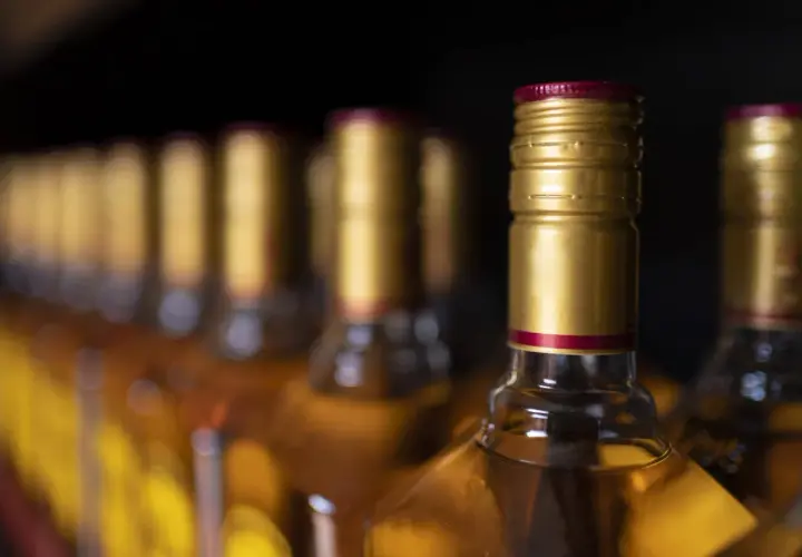 Złote kapsle butelek z alkoholem, przypominające o tym, ile alkoholu można przywieźć z USA do Polski.
