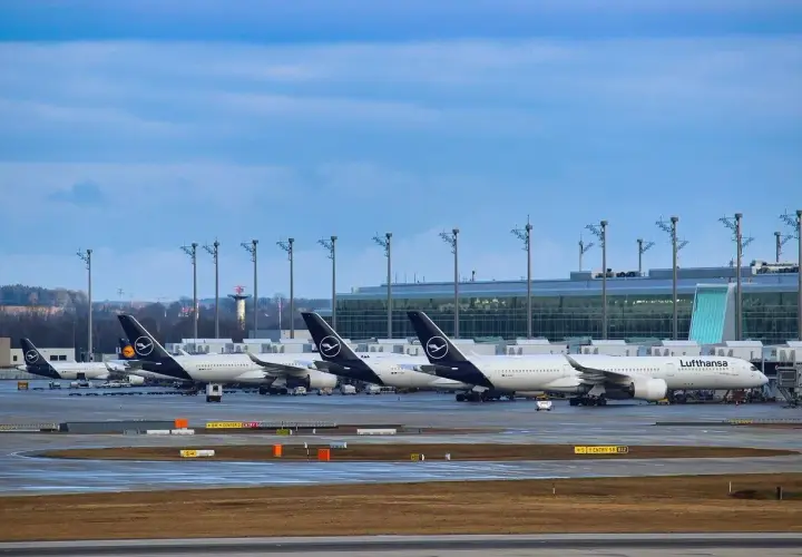 Samoloty Lufthansa na płycie lotniska, w tle nowoczesny terminal. Monachium dworzec autobusowy to nie to miejsce, ale podróż samolotem zaczyna się tutaj.