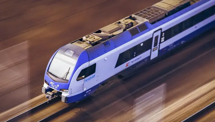 Pociąg PKP Stadler mknie po torach. Warto pomyśleć o zakupie pkp bilety dla dzieci na wakacyjną podróż.