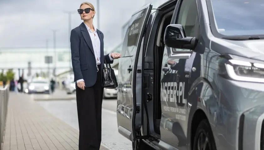 Elegancka kobieta czeka na transfer z Torunia na lotnisko Chopina w Warszawie.