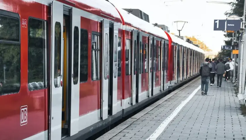 Czerwony pociąg DB z otwartymi drzwiami na peronie. Ludzie czekają, być może na e-ic wymiana biletu.