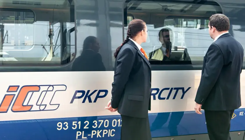 Pracownicy PKP Intercity przy pociągu, gotowi do obsługi pasażerów z biletem weekendowym.